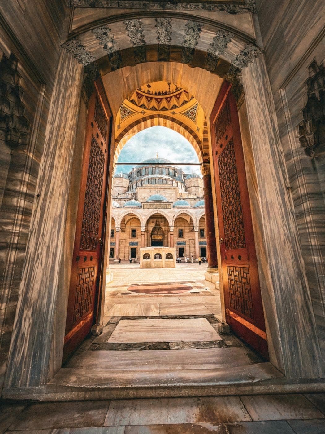 بوابة معمارية مفتوحة على ساحة مسجد لبطاقة المسار العلمي