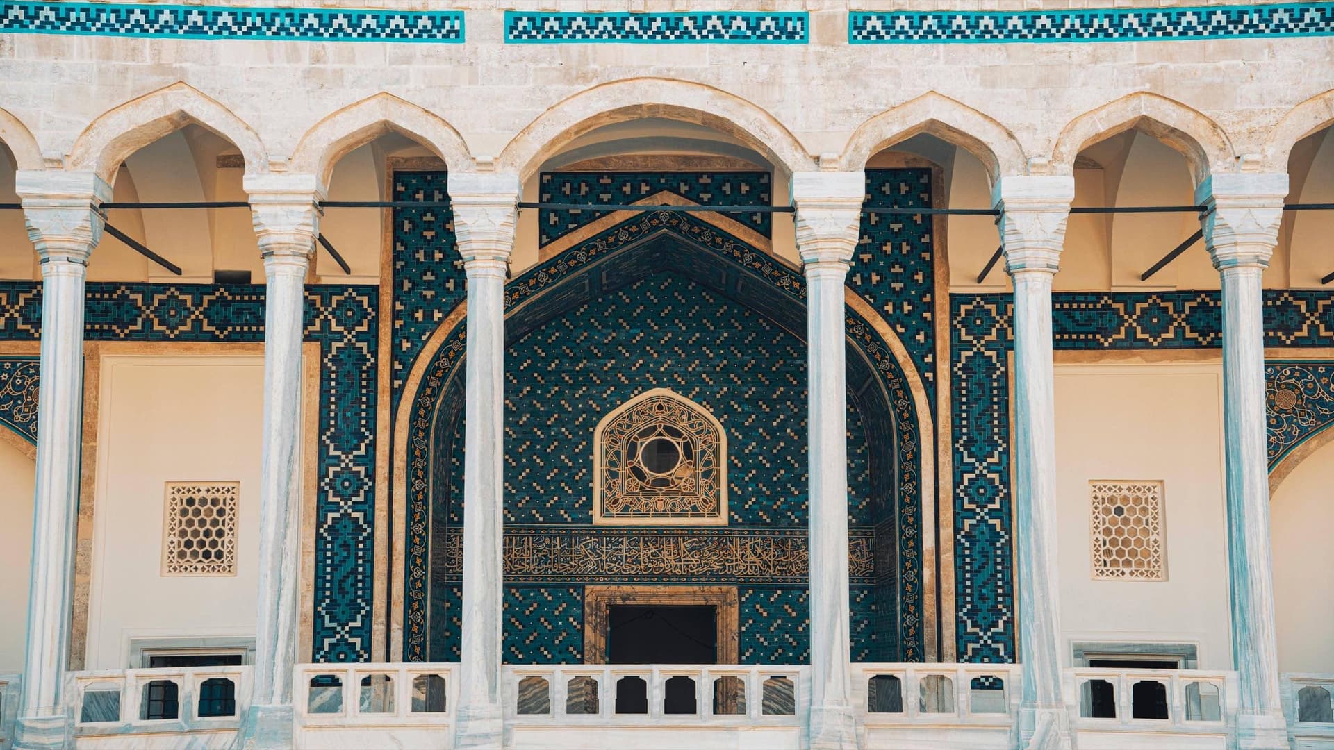 واجهة معمارية مزخرفة بالأعمدة والزخارف الزرقاء لصفحة البرامج المركزة